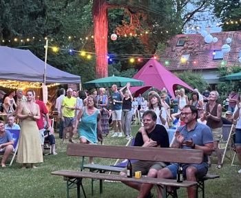 Partygäste und Zelte auf der Wiese